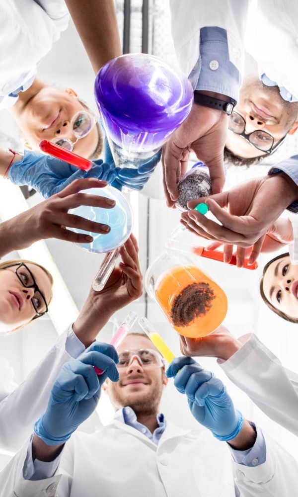 low angle view of scientists holding various test tubes