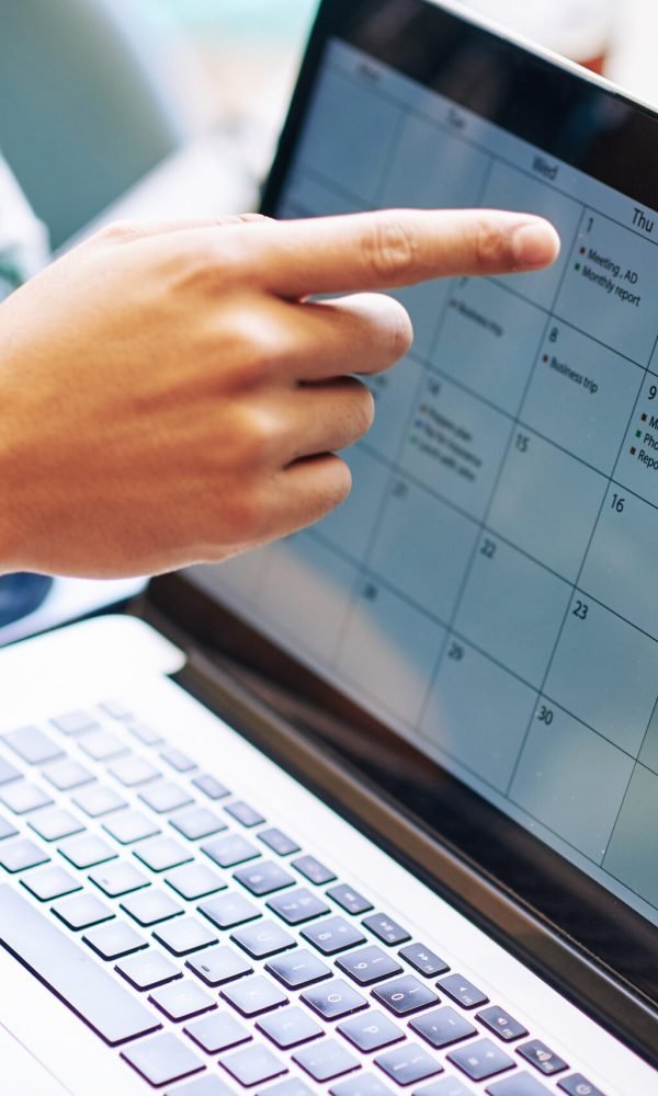 Close-up image of production team discussing working calendar for a month on laptop screen