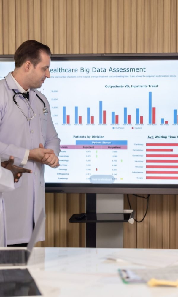 Team of doctors discuss healthcare big data to analyze patient satisfaction trends, waiting status, turnover rates aiming to identify areas for improvement, create cost effective management plans.